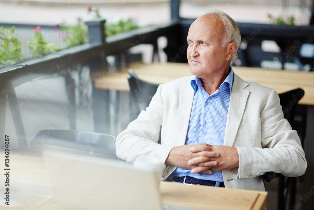 Fototapeta premium Pensive Senior Man at Outdoor Cafe