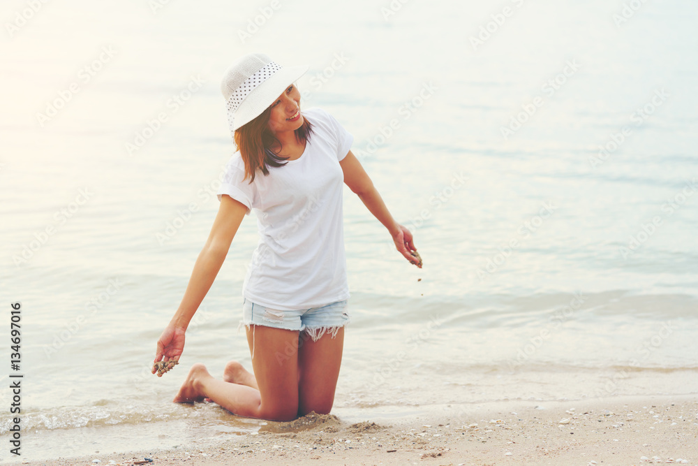 Asian young woman playing sand on the beach