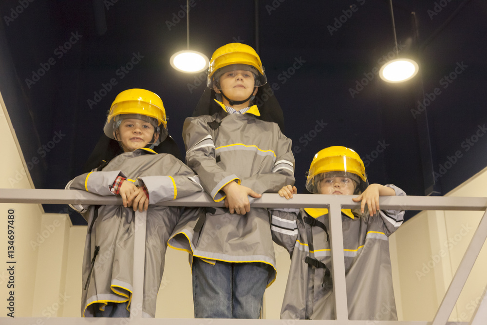 Fototapeta premium Three boys dressed like firefighters