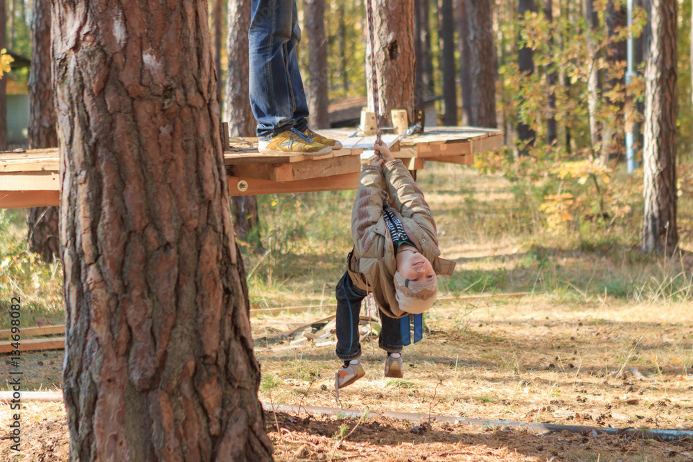 Gomel, Belarus - OCTOBER 5, 2014: Rope town for a family holiday in the countryside. Family competition to overcome aerial obstacles.