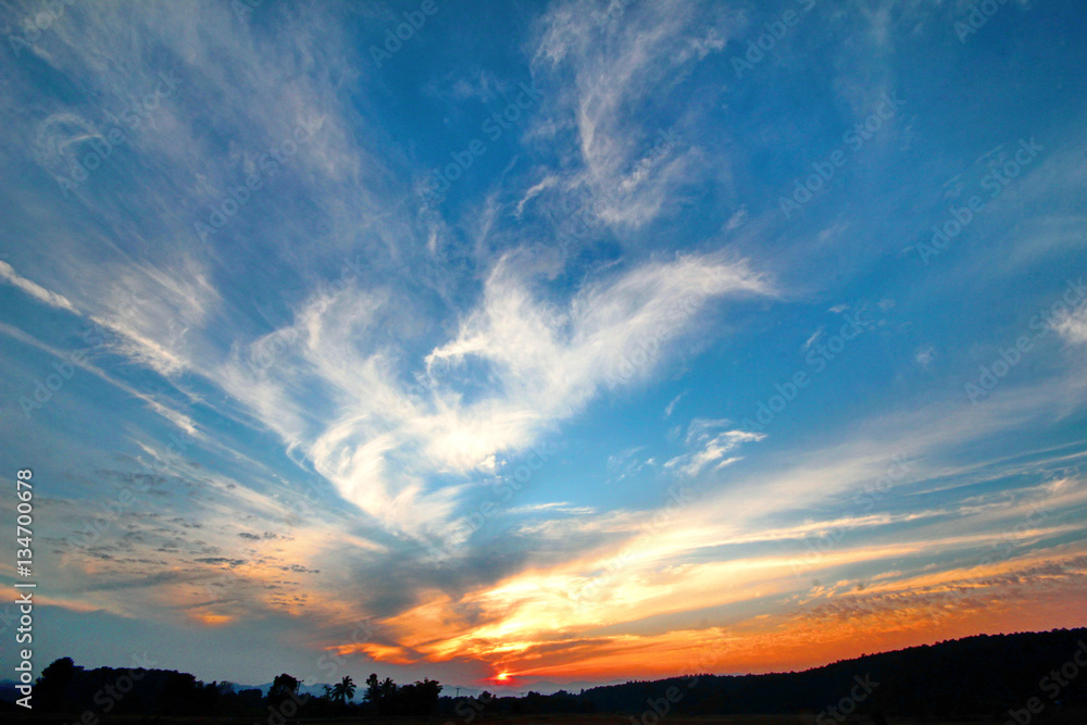 Sky, clouds, mountains, fields and dawn silhouettes.