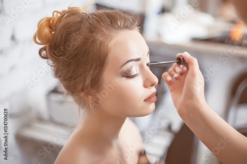 Make-up artist applying the mascara to model.	