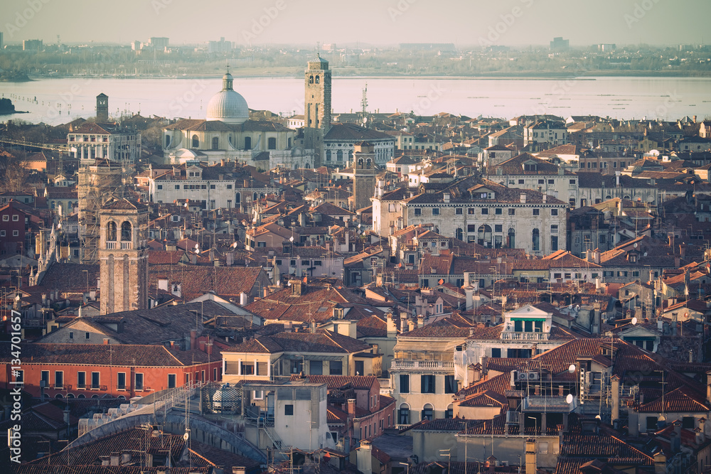 Fototapeta premium Aerial view of Venice, Italy, at sunset with rooftops of buildings and vintage colors in winter afternoon.