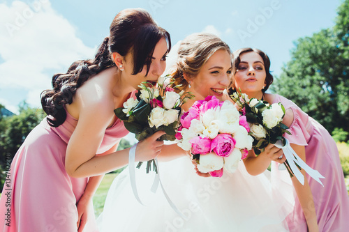 happy Bride with bridesmaids in the park on the wedding day