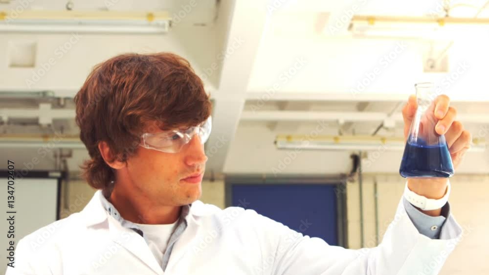Scientist holding Erlenmeyer flask with liquid Scientist holding Erlenmeyer flask with liquid