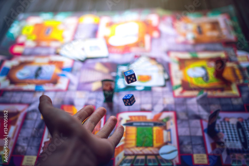 Stampa su Tela Hand throws the dice on the background of Board games
