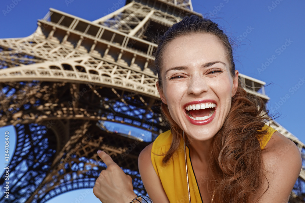 happy woman pointing on Eiffel tower in Paris, France