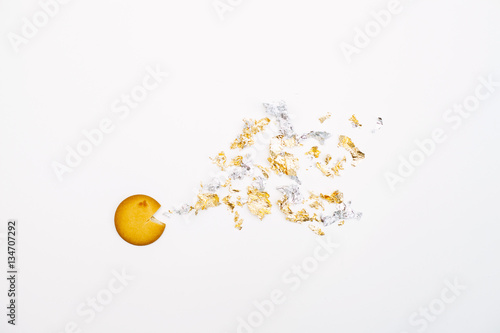 A funny scene with a round cookie and confetti, isolated top view
