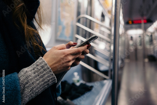 Cuadro en lienzo Women hands holding mobile phone in subway train