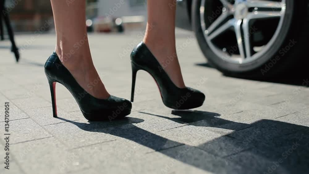 Close-up - the woman in high heels get out from the car Close-up - the woman in high heels get out from the car