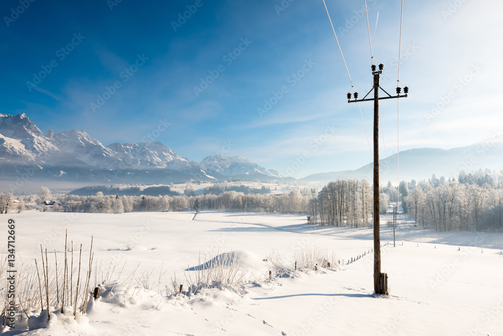 Austrian Winter Wonderland with mountains, fresh snow and haze in the sunlight
