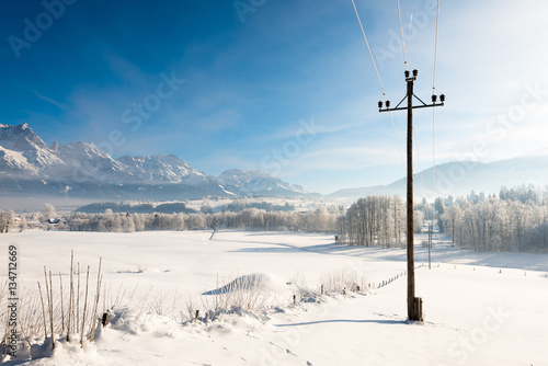 Austrian Winter Wonderland with mountains, fresh snow and haze in the sunlight photo