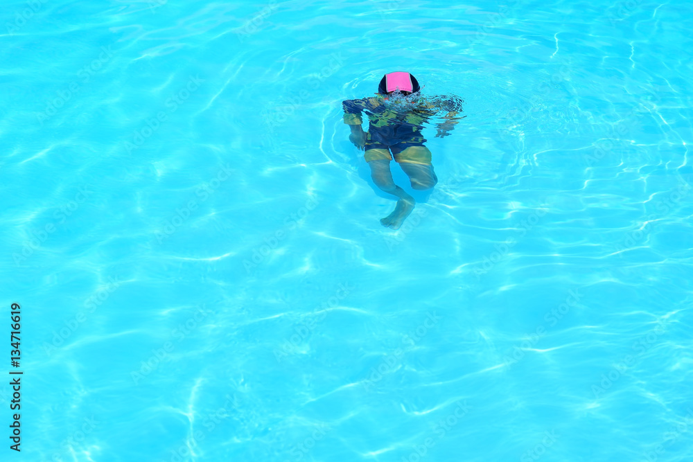 Boy swimming alone in the swimming pool