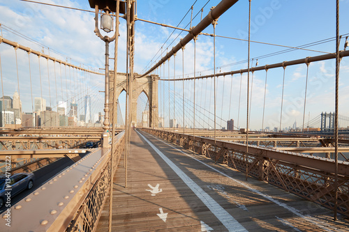 Empty Brooklyn Bridge perspective view in the morning sunlight in New York