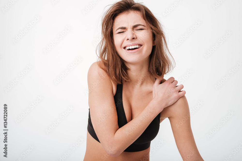 Sad frowning young woman athlete having shoulder pain Sad frowning young woman athlete having shoulder pain