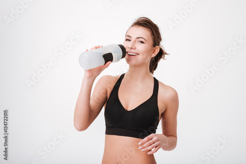 Sporty young woman drinking water