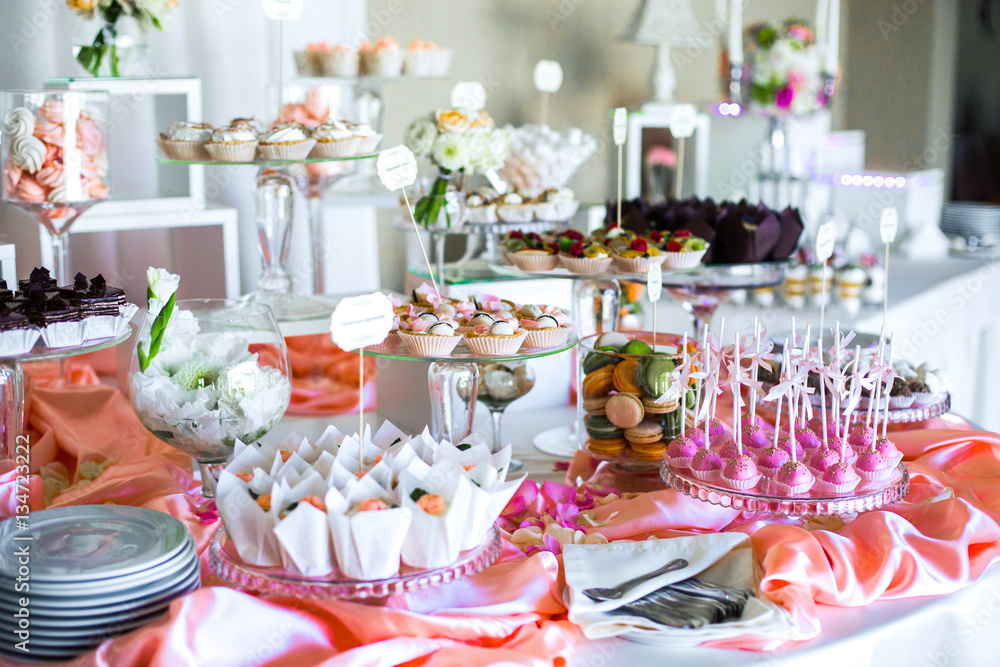 Table with delicious sweets covered with pink silk Table with delicious sweets covered with pink silk