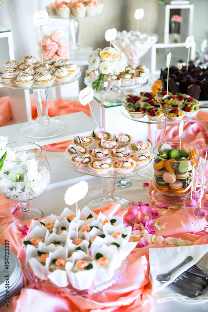 Table with delicious sweets covered with pink silk Table with delicious sweets covered with pink silk
