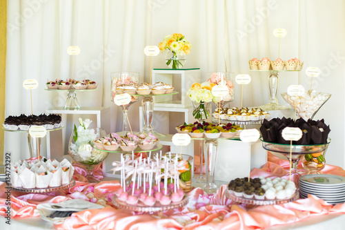 Beautiful candy bar covered with pink silk and served with glass © IVASHstudio