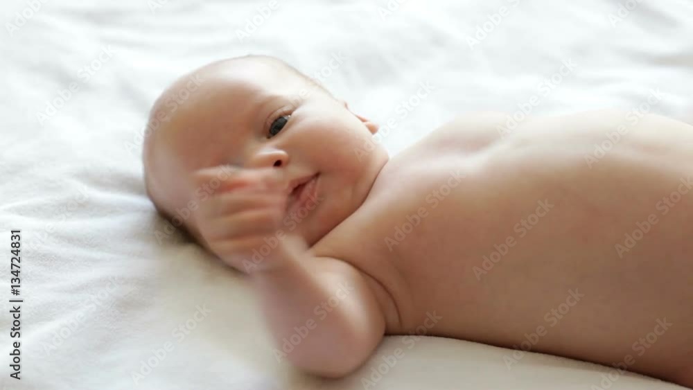 Little cute newborn baby boy lying on bed and looking at Little cute newborn baby boy lying on bed and looking at