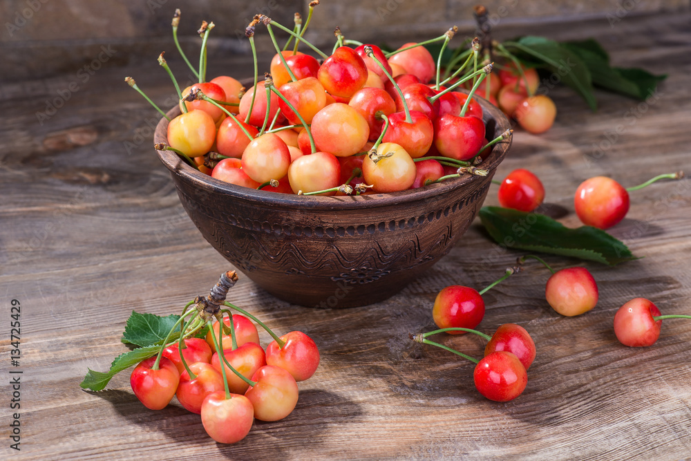 Fragrant and ripe cherries in a plate on a wooden background. selective focus Fragrant and ripe cherries in a plate on a wooden background. selective focus