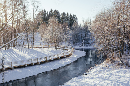 Winter park with snow trail and river at sun day photo