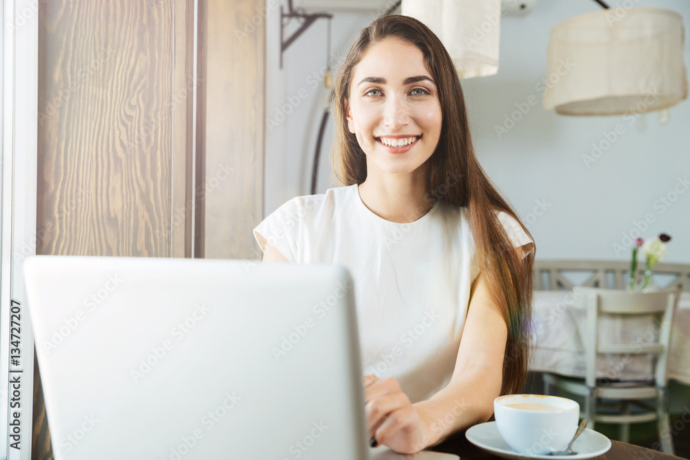 Pretty smiling business woman using laptop in restaurant Pretty smiling business woman using laptop in restaurant