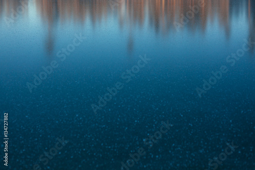 Blurred forest at sunset in frozen lake