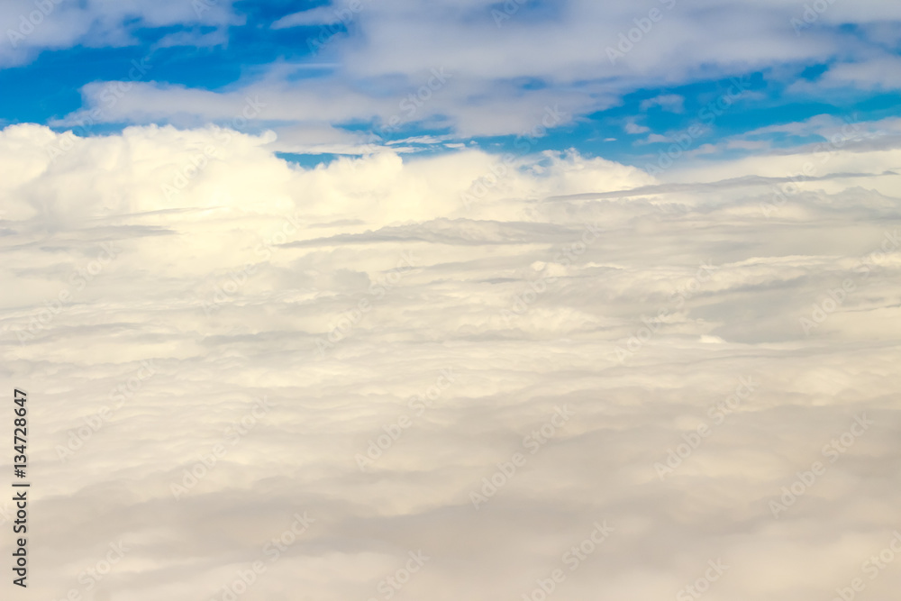 Fototapeta premium Beautiful cloudscape from sky aerial view. Beauty of nature view from above the sky and clouds. White clouds and blue sky view from airplane window. Sunlight in the sky shines on clouds.