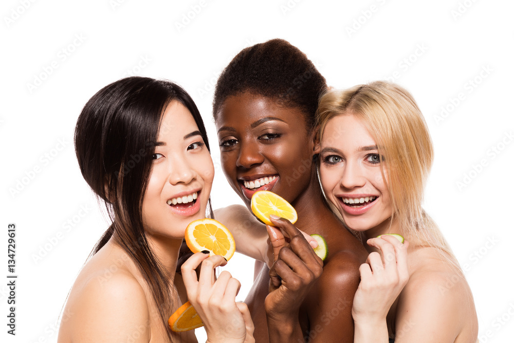 three different ethnic women with lemon, orange and cucumber three different ethnic women with lemon, orange and cucumber