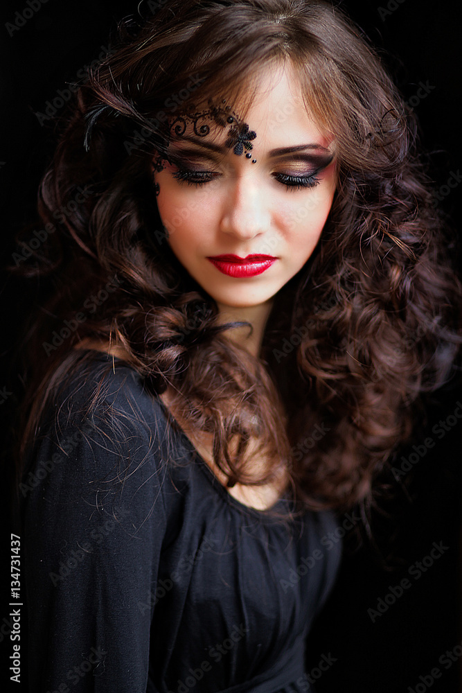 A beautiful witch. Gorgeous woman with black patterns on her fac A beautiful witch. Gorgeous woman with black patterns on her fac