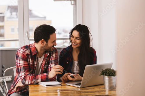Couple Working Together At Desk In Home Office