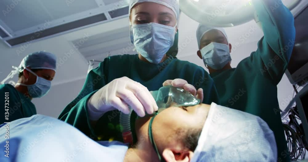 Surgeon putting oxygen mask on patient in operation room at the hospital 4k