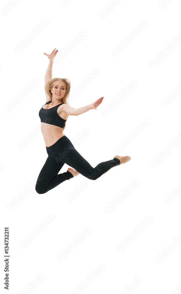 Slim sportswoman gracefully jumping in studio