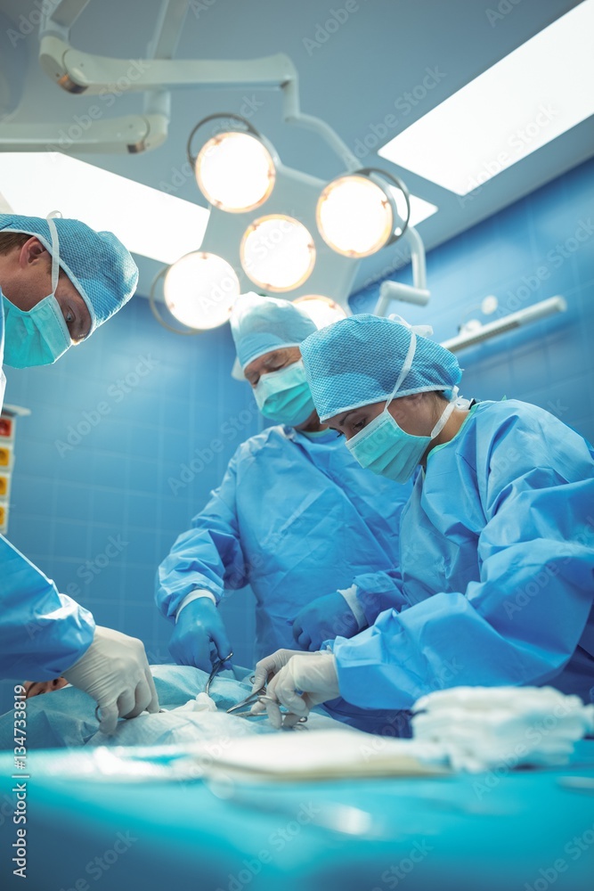 Team of surgeons performing operation in operation theater StockFoto