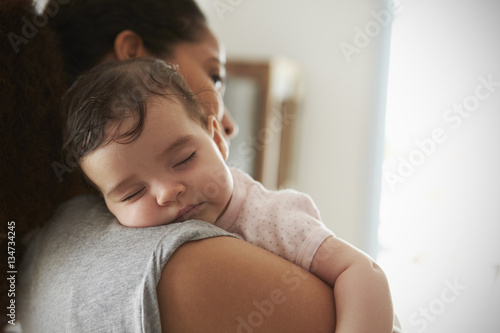Φωτογραφία Close Up Of Mother Cuddling Sleeping Baby Daughter At Home