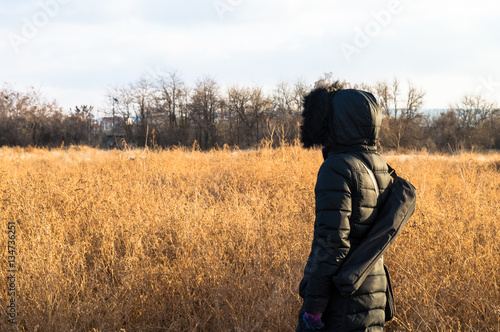 Woman in black standing alone in a field