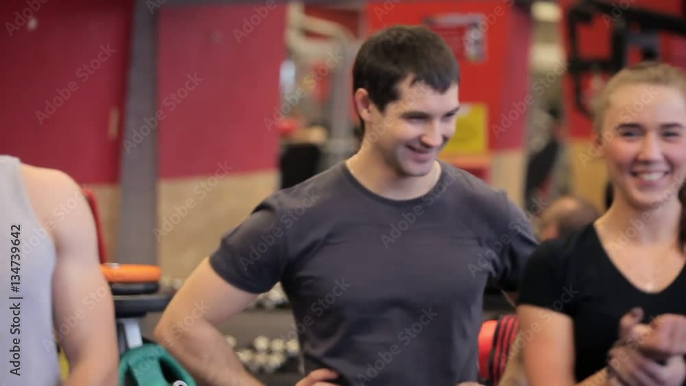 Close up of Athletic woman sweating taking a break after work out. People talk in the gym before the training. group of people laugh and talk in the gym. group of people Close up of Athletic woman sweating taking a break after work out. People talk in the gym before the training. group of people laugh and talk in the gym. group of people