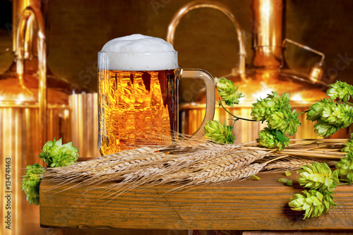 Фотография Beer glass with hops and barley in the brewery