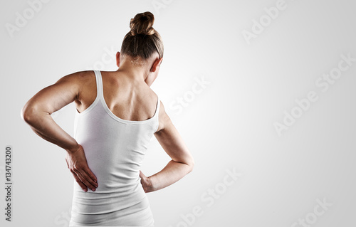 Young female in white shirt suffering from backache. Scoliosis treatment concept. 