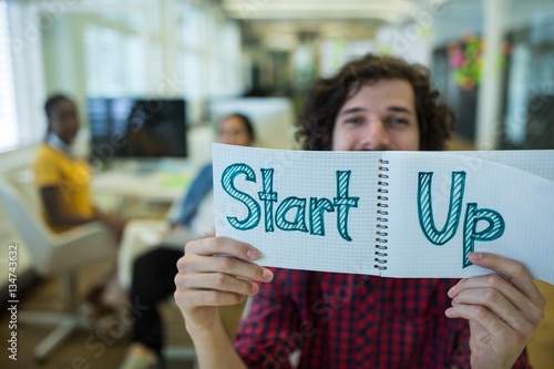 Wallpaper Mural Male business executive holding diary with text start up Torontodigital.ca