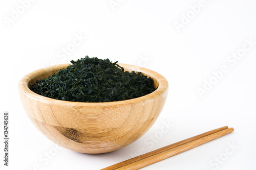 Dried japanese wakame seaweed in a bowl, isolated on white background 