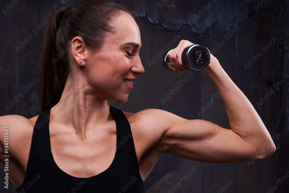 Plakat Indoors shot of perfectly trained biceps of woman arm isolated o