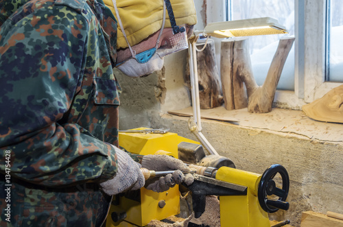 Carpenter sharpens the wood on a lathe
