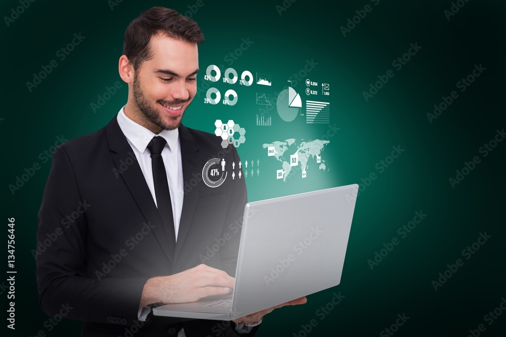 Composite image of smiling businessman standing and using laptop Composite image of smiling businessman standing and using laptop