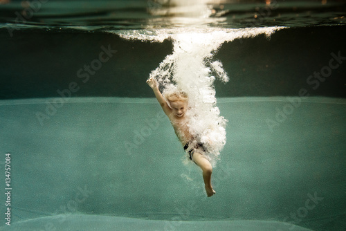 Boy jumping into pool 