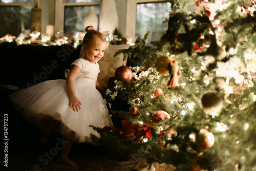 Young girl standing beside christmas tree 