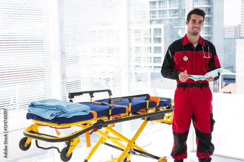 Portrait of handsome paramedic with medical report photo