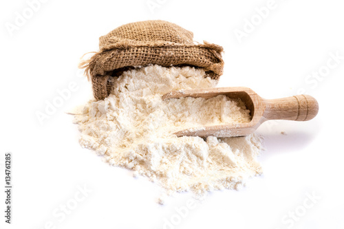Weizenmehl in Leinensack mit Holzschaufel isoliert auf weiß