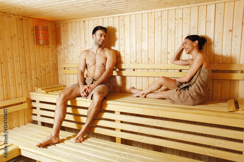 Attractive young couple relaxing in sauna